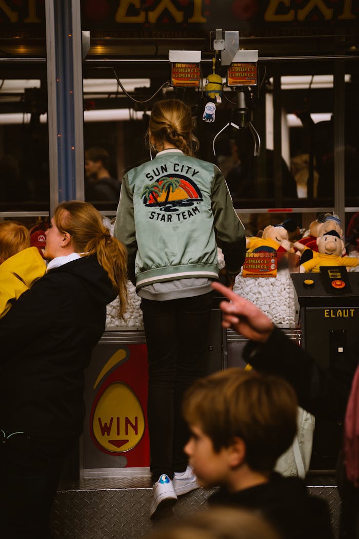 Kids enjoying a claw crane game in an arcade setting, capturing fun moments indoors.