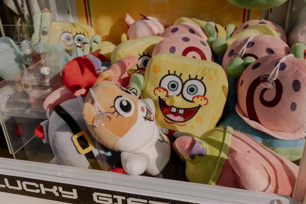 A vibrant claw machine filled with various plush toys at an arcade, offering fun entertainment.